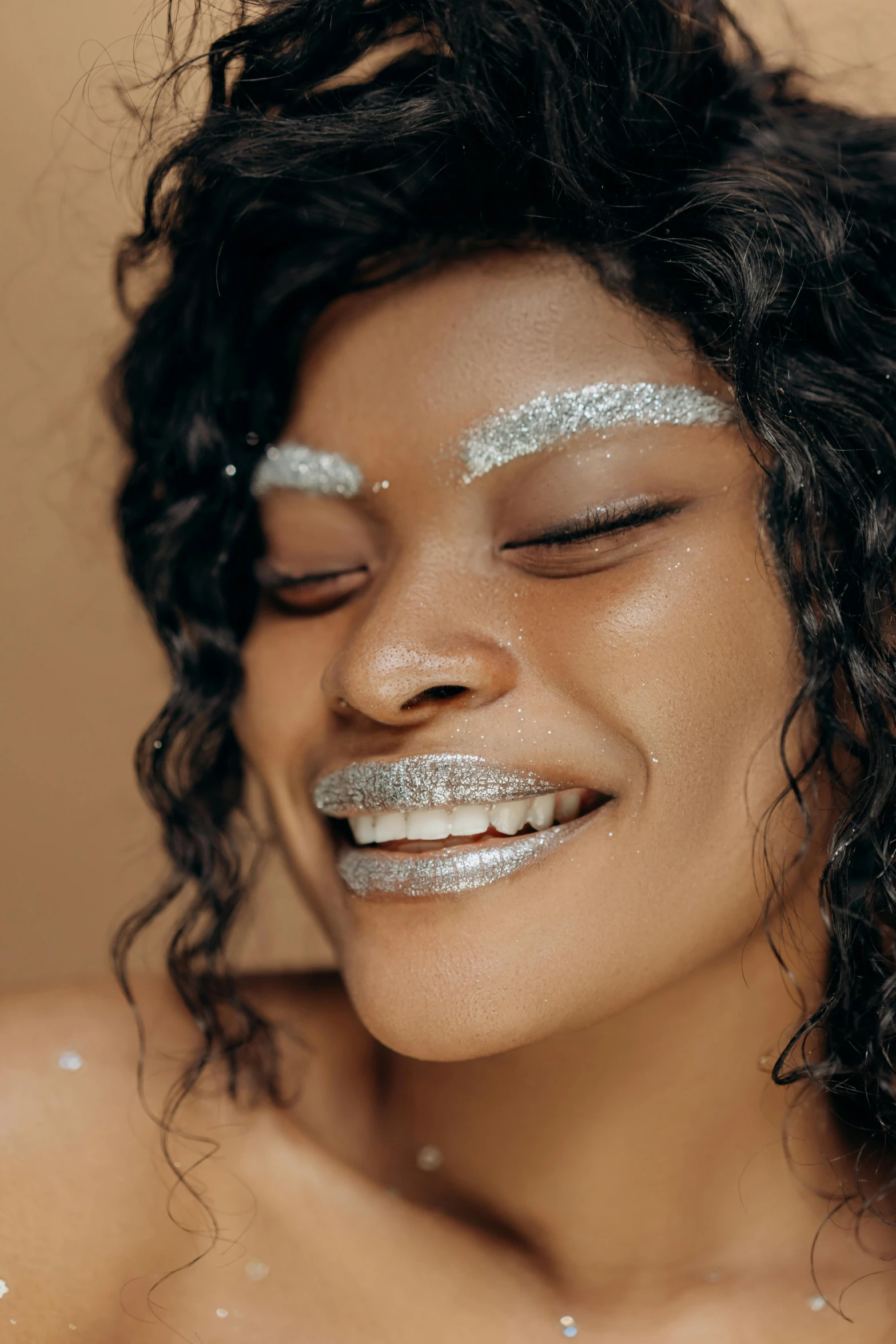 a close up of a woman with glitter on her face, an album cover, trending on pexels, afrofuturism, smiling playfully, silver，ivory, photoshoot for skincare brand, woman is curved