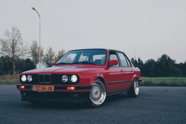 a red car parked in a parking lot, pexels contest winner, renaissance, bmw e 3 0, photo-realistic low lighting, retro haze, norwegian