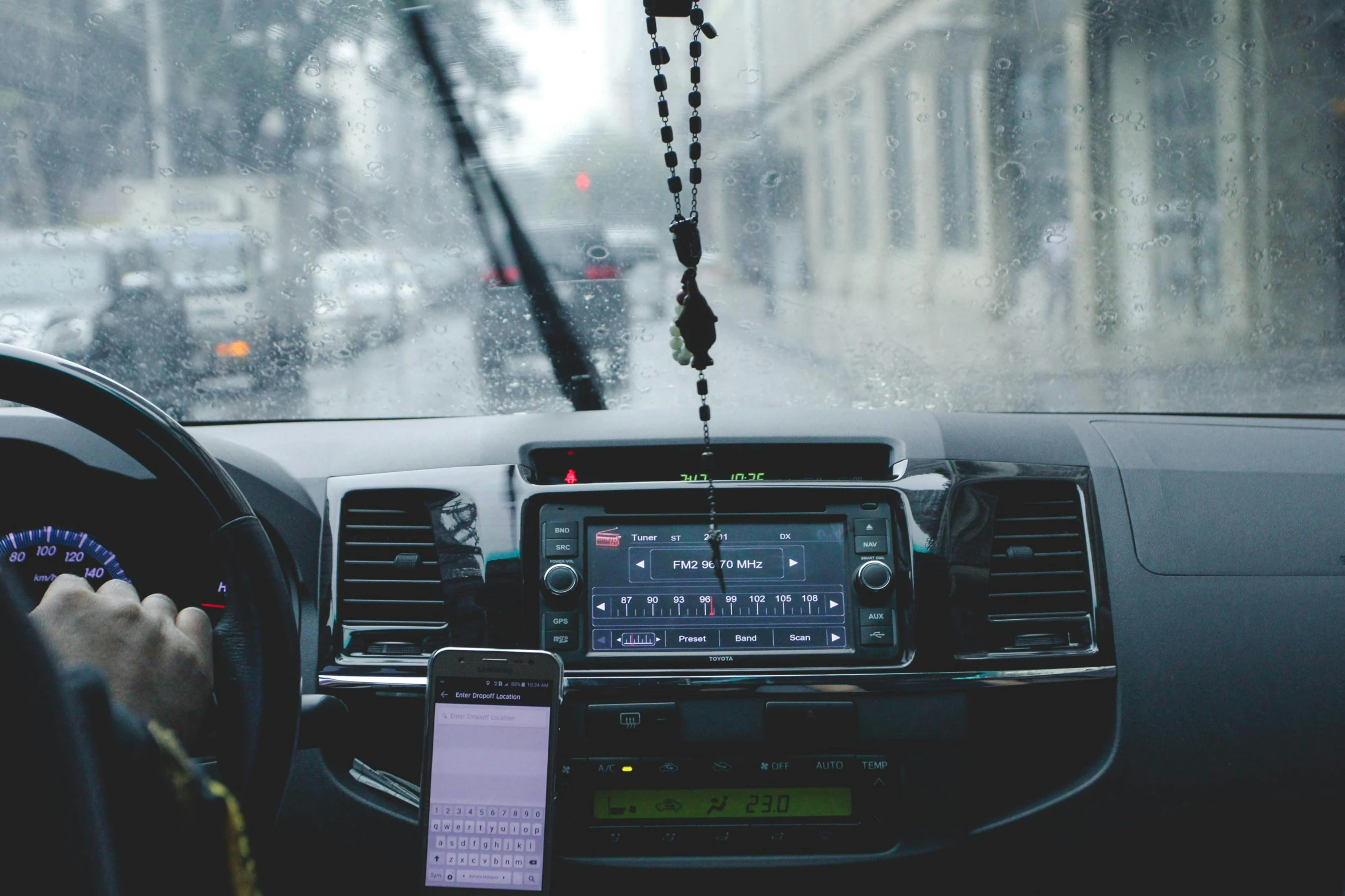 a person driving a car in the rain, trending on pexels, graffiti, with head phones, phone photo, things hanging from ceiling, radio