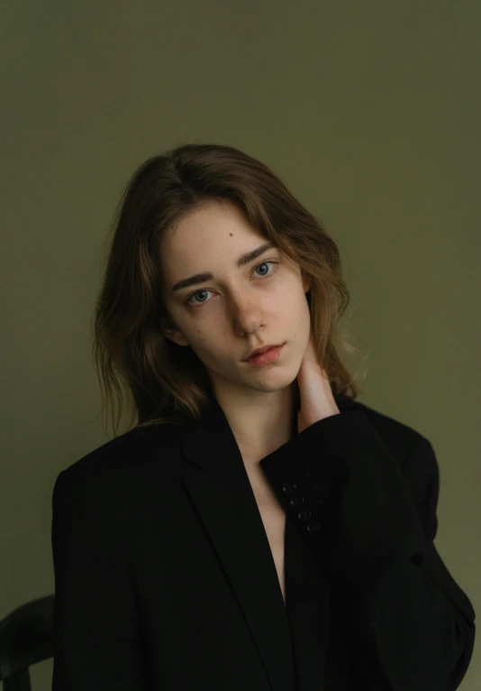 a woman in a black suit posing for a picture, an album cover, inspired by Elsa Bleda, trending on unsplash, realism, portrait androgynous girl, hana alisa omer, soft oval face, thin aged 2 5