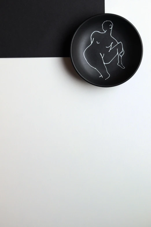 a plate with a drawing of a man on it, inspired by Robert Mapplethorpe, unsplash, minimalism, shapely derriere, chalk, bowl, black colors