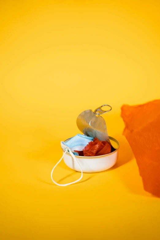 a tin of food sitting on top of a table, a still life, by Gavin Hamilton, pexels, conceptual art, orange color, pouches, covid, floating objects