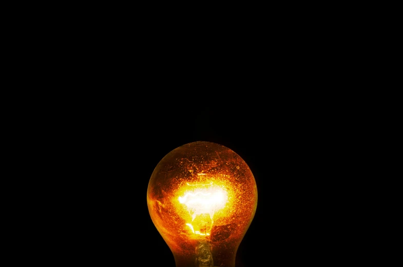 a light bulb that is glowing in the dark, by Adam Chmielowski, realism, large electrical gold sparks, brown, one light, orange light