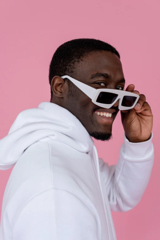 a man in a white hoodie and sunglasses, inspired by Ay-O, trending on pexels, ( ( dark skin ) ), on a pale background, non binary model, discord profile picture