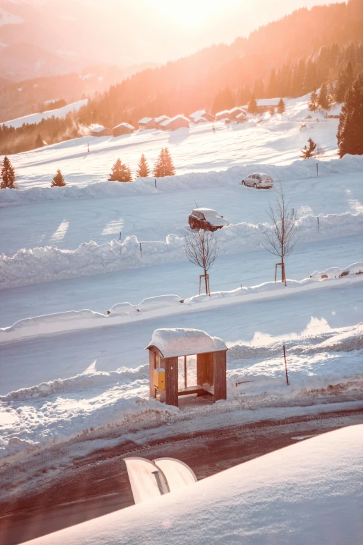 a man flying through the air while riding a snowboard, a tilt shift photo, by Daniel Seghers, trending on unsplash, wooden toilets, sunset in a valley, bus stop, covered in snow