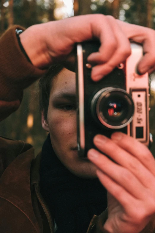 a person taking a picture with a camera, by Adam Marczyński, lovingly looking at camera, looking into a mirror, color footage, ansel ]