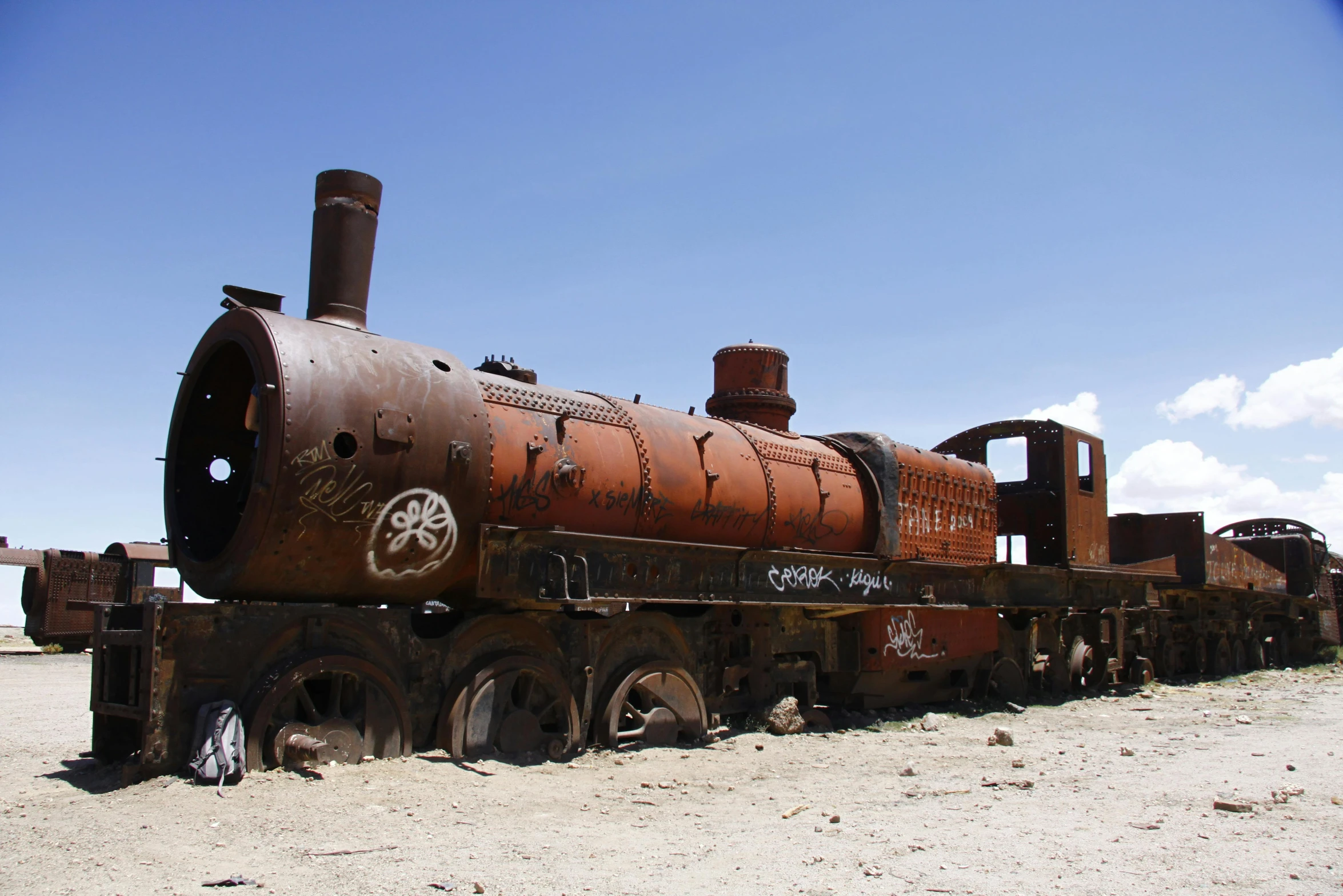 an old rusted train sitting in the desert, an album cover, unsplash, constructed upon salar de uyuni, steam punk grafitti, jenny seville, museum photo