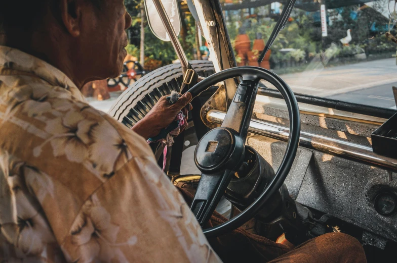 a man sitting at the wheel of a bus, pexels contest winner, bali, square, thumbnail, brown