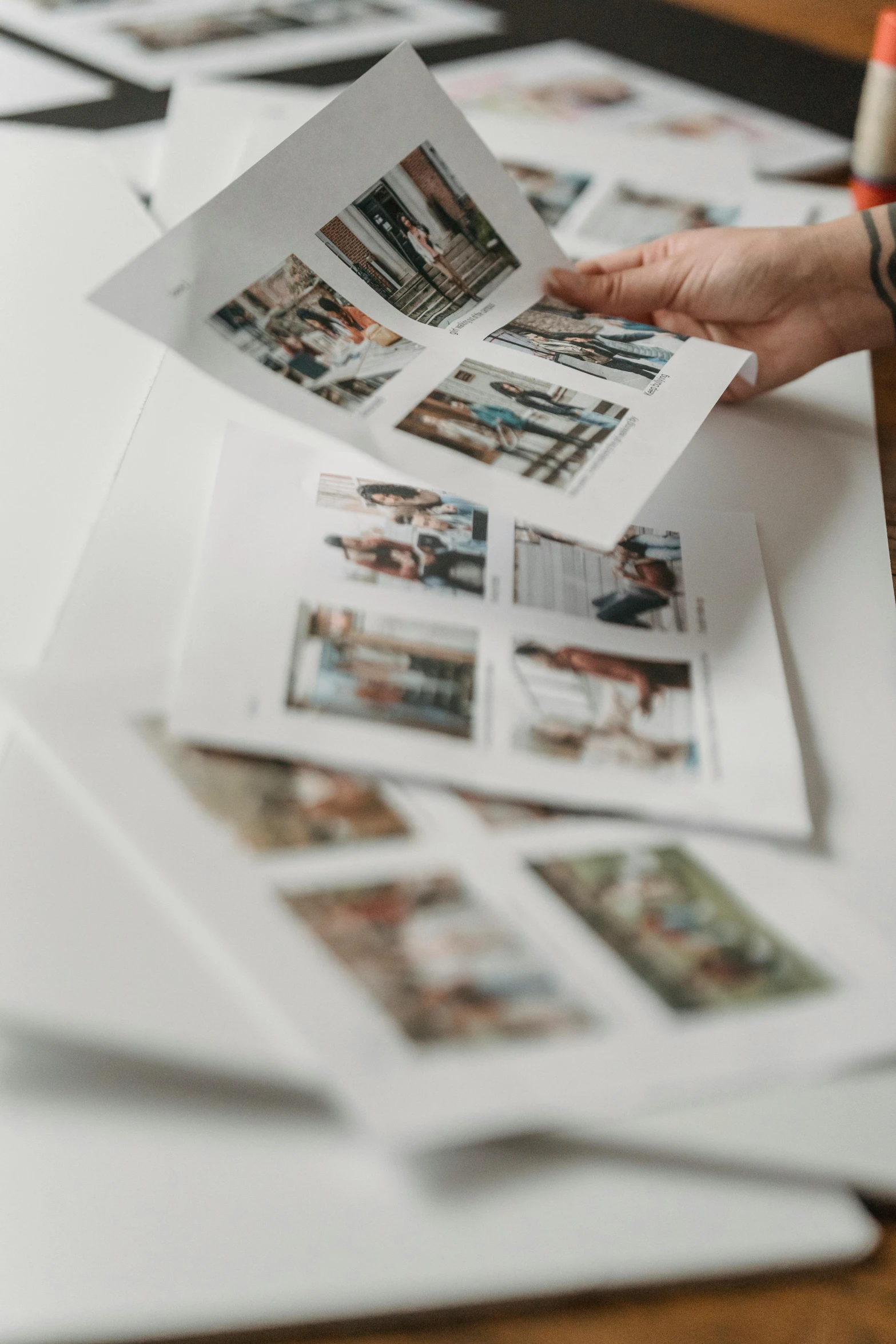 a person holding a piece of paper on top of a table, a picture, collection product, candid photography, graphic print, multi-part