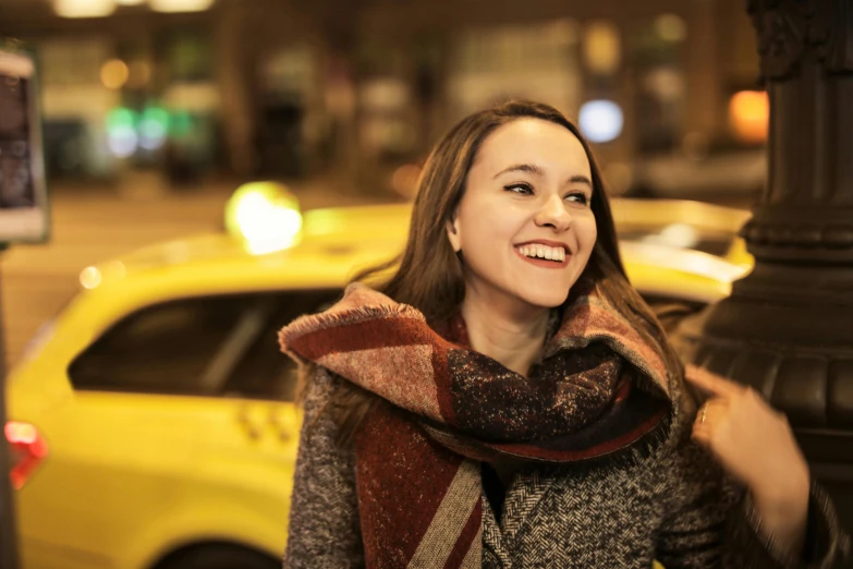 a woman standing on a city street at night, a photo, taxi, smiling, avatar image