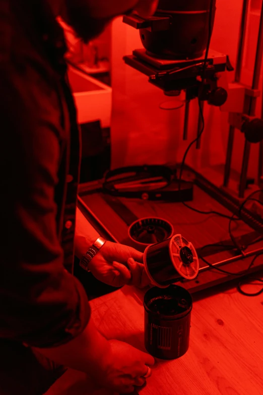 a man standing in front of a red light, process art, in a lab, lighting her with a rim light, darkroom, 3 d print