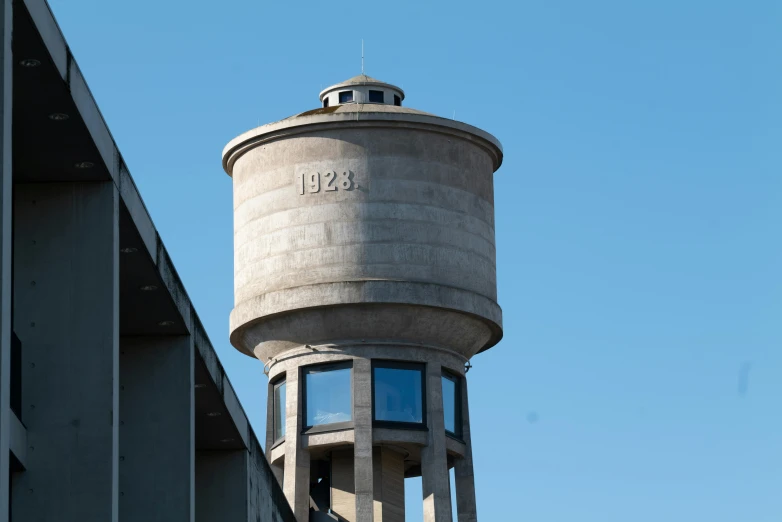 a water tower on the side of a building, inspired by Robert Bechtle, unsplash, brutalism, 2 0 2 2 photo, large head, preserved historical, westside