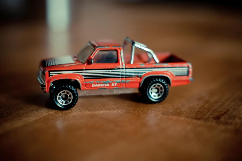 a toy truck sitting on top of a wooden table, pexels contest winner, photorealism, 80s red sports car, micro machines, cowboy shot, striped