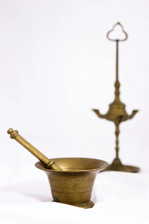 a pair of brass mortars on a white background, an album cover, flickr, folk art, mortar and pestle, argand lamp, photograph credit: ap, 2708519935