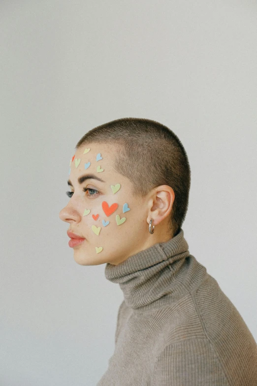 a woman with hearts painted on her face, an album cover, by Winona Nelson, trending on pexels, antipodeans, shaved haircut, artem chebokha, pastel', compassionate