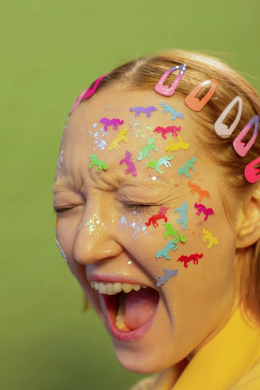 a close up of a child with paint on her face, an album cover, inspired by Damien Hirst, trending on pexels, pop art, puffy sticker, pony, licking out, teenage girl