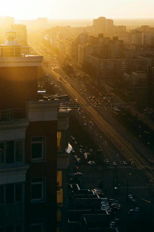 a view of a city from the top of a building, unsplash contest winner, realism, sun shines down on the car, mongolia, soft golden light, photorealistic streetscape