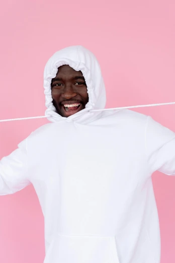 a man in a white hoodie on a pink background, pexels contest winner, ( ( dark skin ) ), laugh lines, cloth simulation with houdini, lots of white cotton