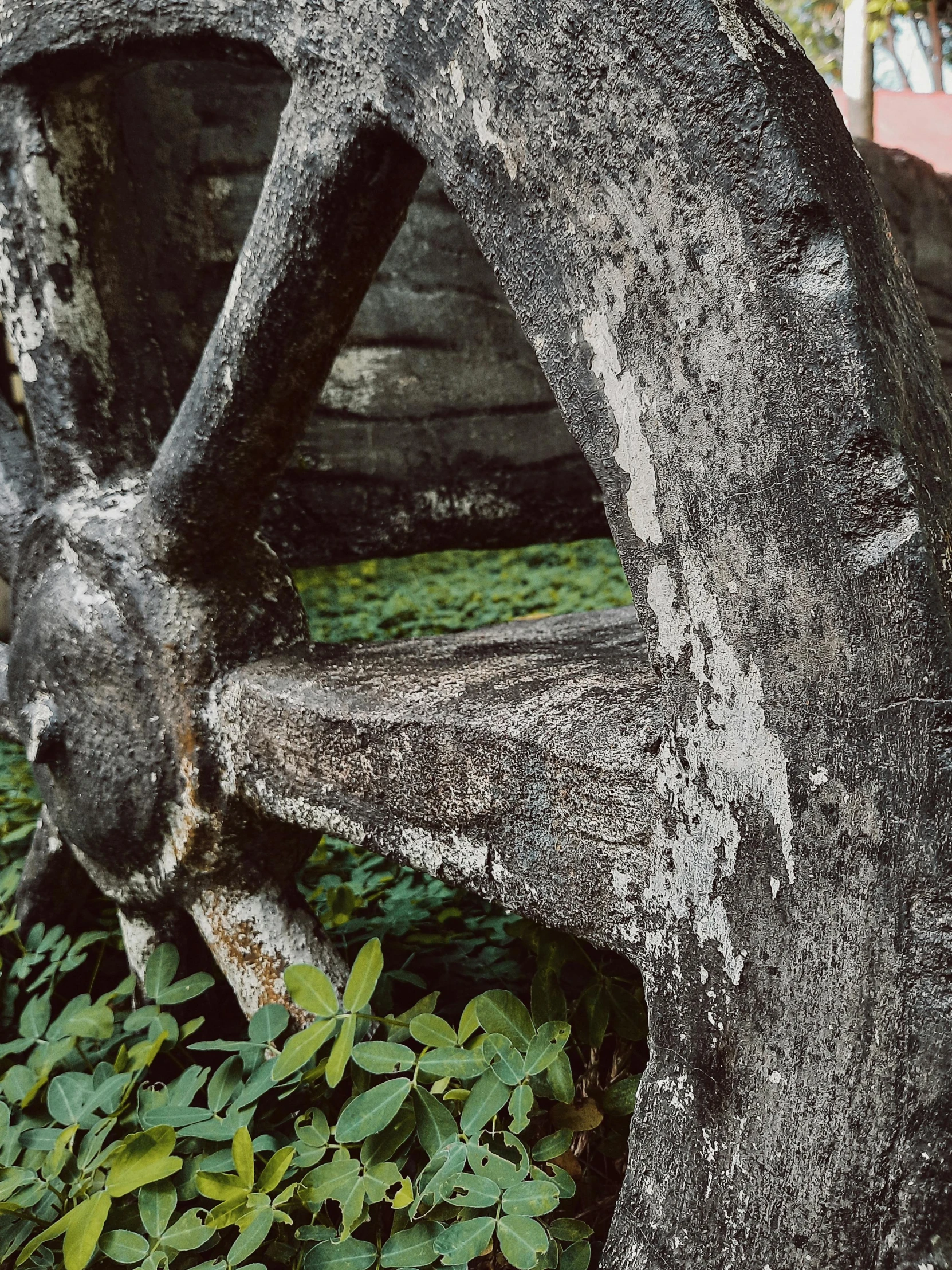 a wooden wagon wheel sitting on top of a lush green field, inspired by Thomas Struth, unsplash, visual art, tikal temple iv, detail structure, archival pigment print, made of stone and concrete