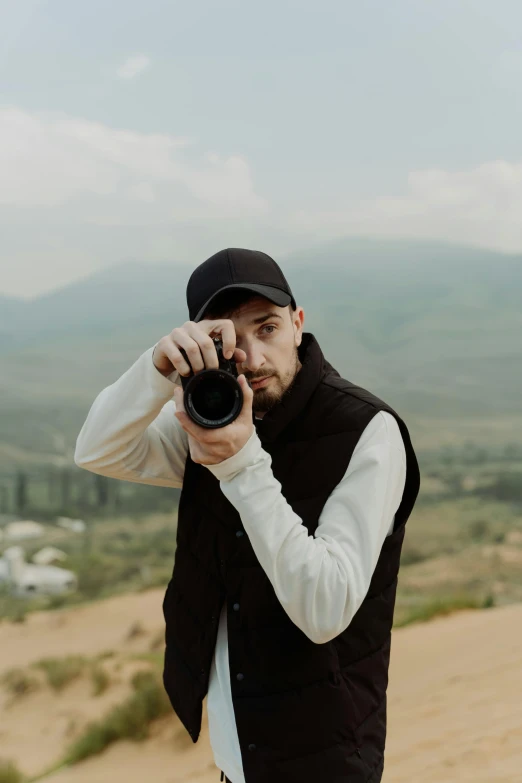 a man taking a picture with a camera, with mountains as background, dmitry prozorov style, halfbody headshot, photography]