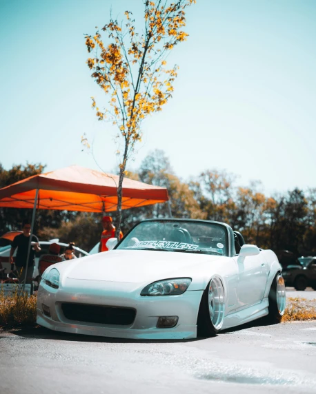 a white sports car parked in a parking lot, inspired by Hiroshi Honda, unsplash contest winner, festivals, trending on vsco, soft top, perfectly shaded body
