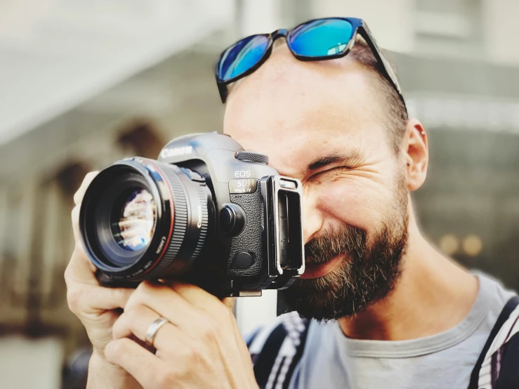 a man taking a picture with a camera, pexels contest winner, photorealism, headshot profile picture, smiling into the camera, telephoto, colour photograph