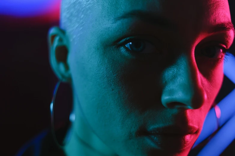 a close up of a person holding a cell phone, a character portrait, by Adam Marczyński, pexels contest winner, bisexual lighting, portrait of bald, african american woman, low saturated red and blue light