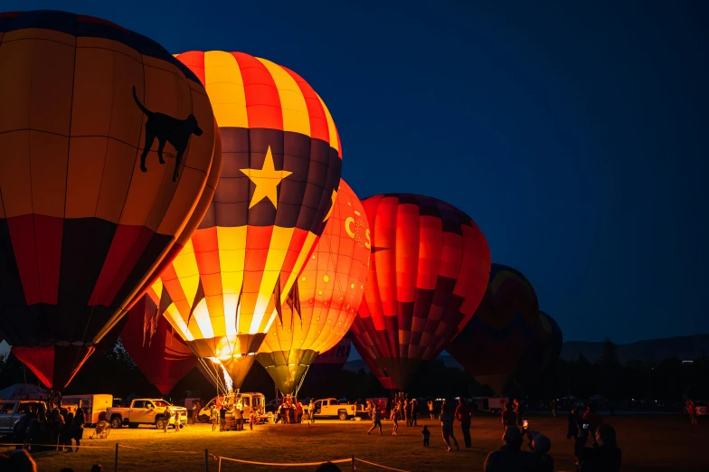 a group of hot air balloons sitting on top of a field, by Winona Nelson, pexels contest winner, happening, night light, looking off to the side, festivals, take off