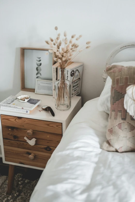 a bed room with a neatly made bed, by Elsie Henderson, pexels contest winner, visual art, books on side table, natural materials, white, upcycled