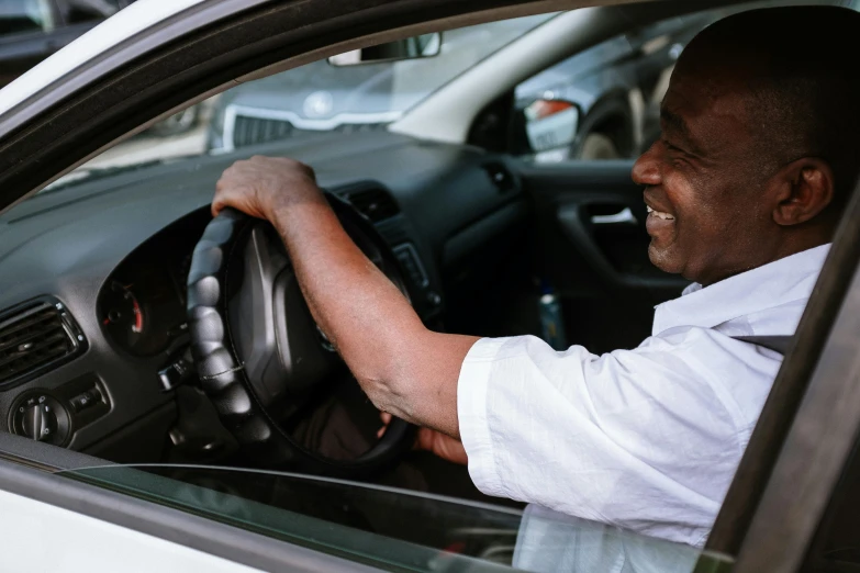 a man sitting in the driver's seat of a car, pexels contest winner, happening, brown skin man with a giant grin, older male, looking around a corner, profile image