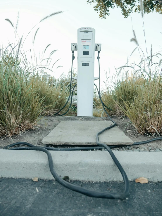 an electric charger sitting on the side of a road, by Ryan Pancoast, dry ground, full frame image, monument, contain
