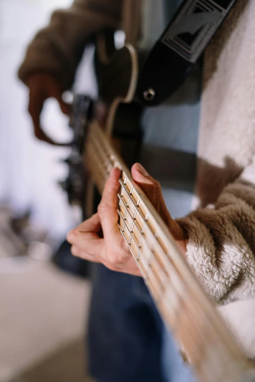 a close up of a person holding a guitar, wearing a cardigan, bass music, lined up horizontally, carefully crafted