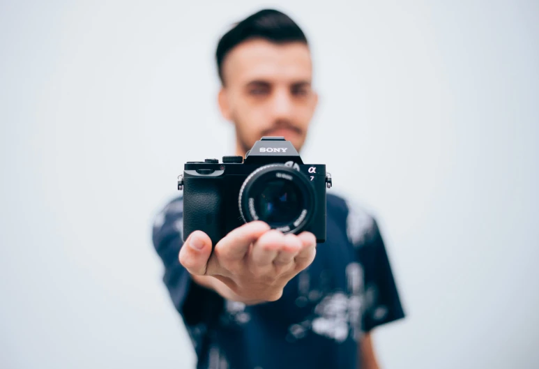 a man holding a camera in front of his face, a picture, sony a7, blurred, minimalist photo, instagram post 4k