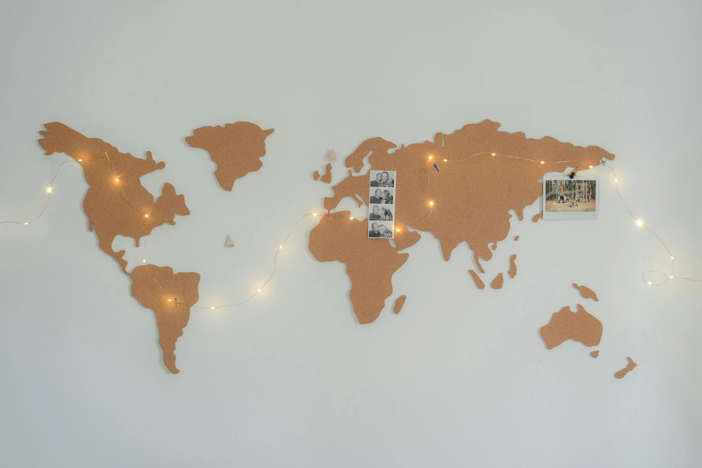 a map of the world is displayed on a wall, by Arabella Rankin, pexels contest winner, string lights, terracotta, on a gray background, instagram post