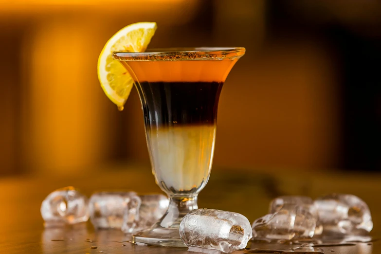 a shot of liquor with a slice of lemon on the rim, inspired by Carlo Martini, unsplash, black and orange, smoked layered, scorpion tail, cold brew coffee )