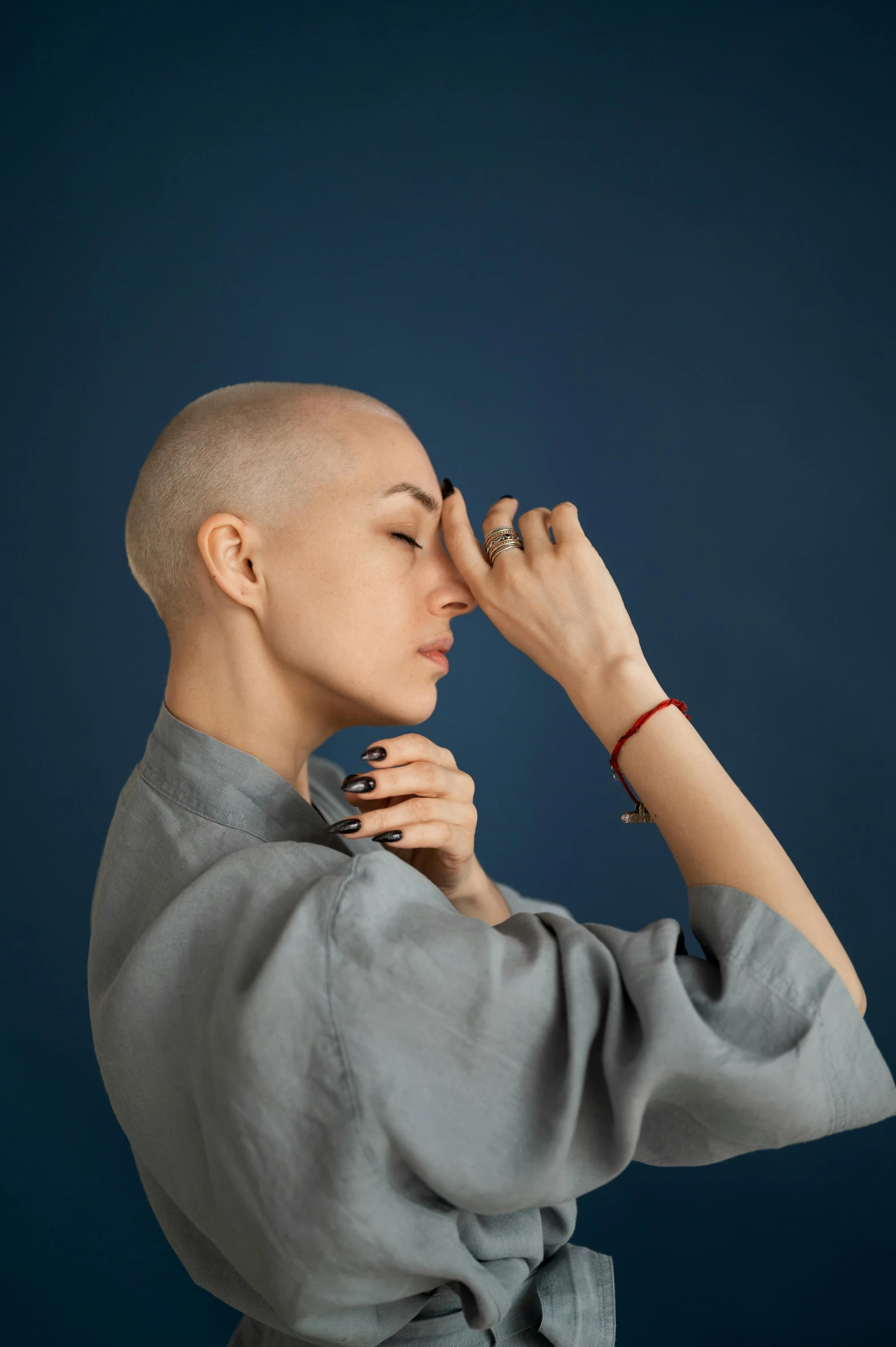 a close up of a person with a bald head, an album cover, inspired by Anna Füssli, solemn gesture, model posing, adar darnov, closes her eye