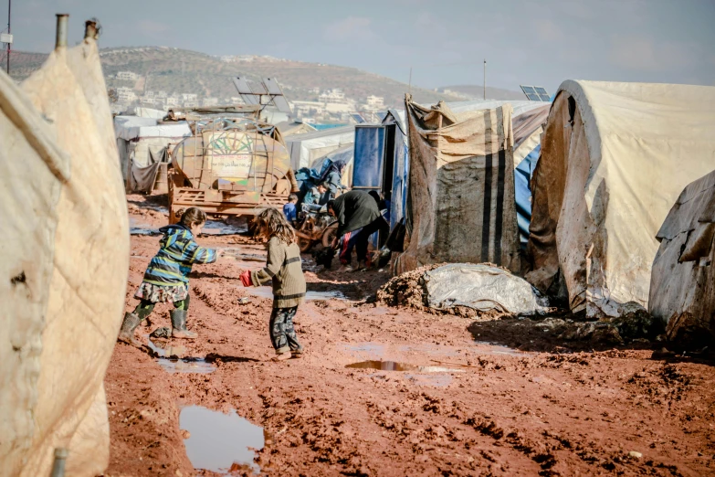 a couple of people that are standing in the dirt, by Ibrahim Kodra, trending on unsplash, hurufiyya, makeshift houses, refugees, tents, poop