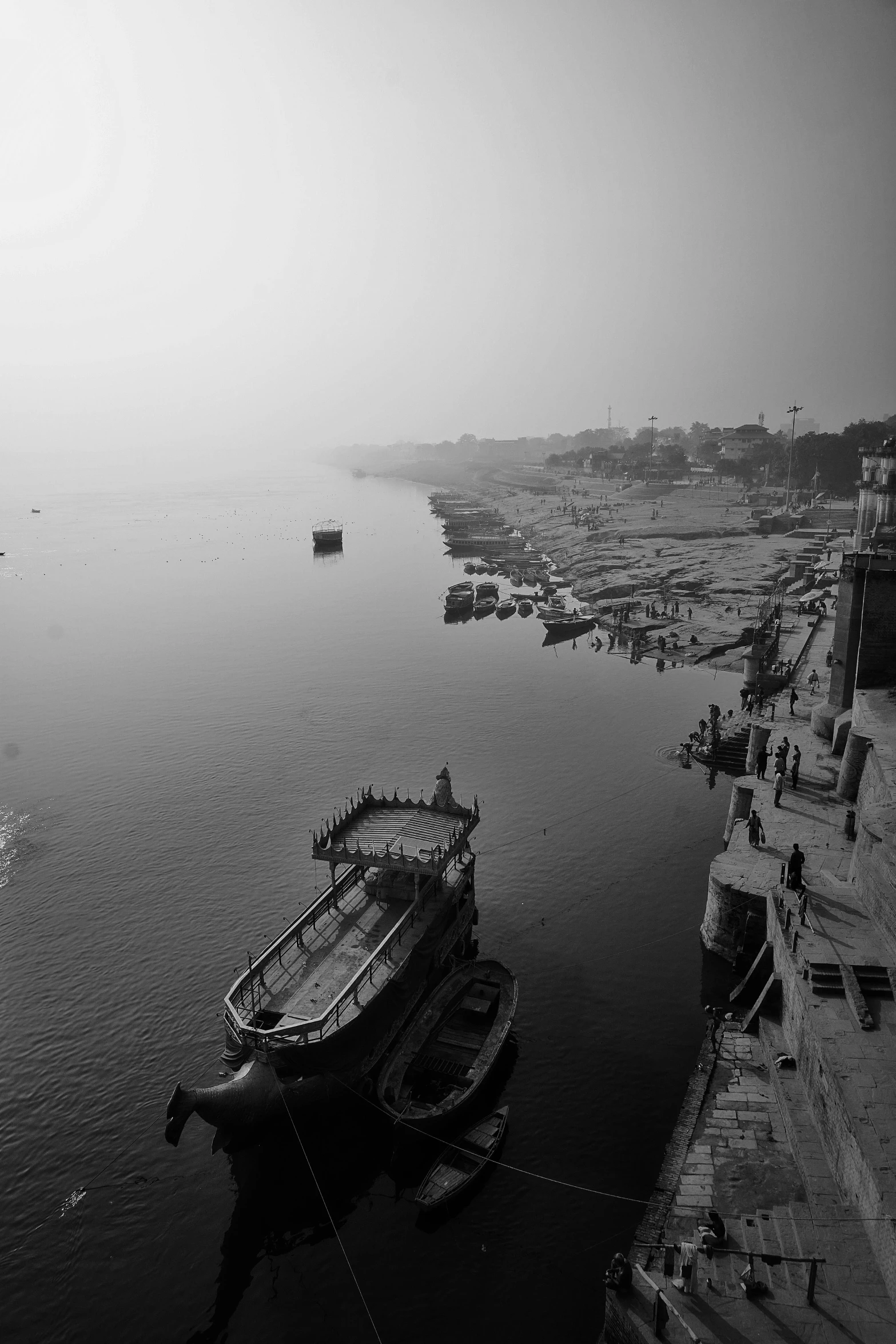 a black and white photo of a boat in the water, a black and white photo, by Sudip Roy, dada, scenic view of river, city morning, detailed medium format photo, view from high