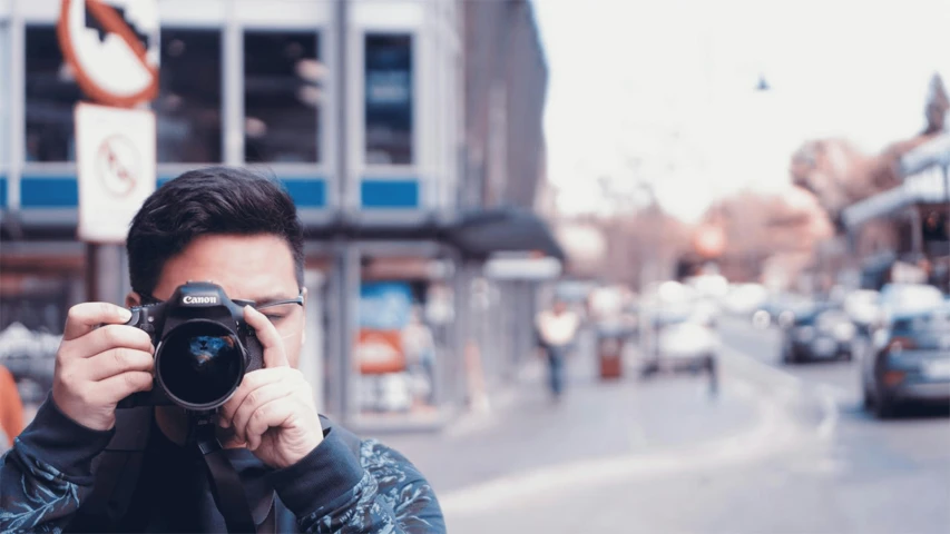 a man taking a picture with a camera, pexels contest winner, photorealism, standing in a city street, professional profile picture, coloured photo, intricate sharp focus