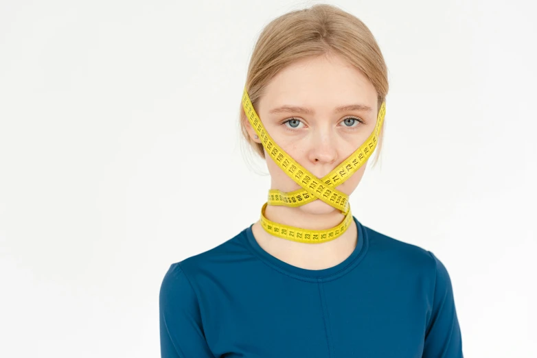 a woman with a tape around her mouth, inspired by Sarah Lucas, trending on pexels, anorexic figure, measurements, neoprene, teenage girl