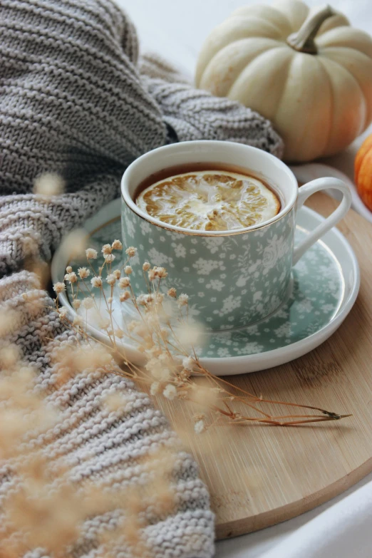 a cup of coffee sitting on top of a wooden tray, a still life, by Jessie Algie, trending on pexels, autumnal, mint, subtle patterns, square