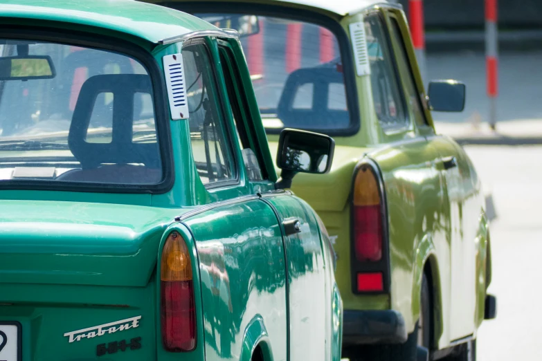 a couple of green cars parked next to each other, a photo, by Sven Erixson, close-up shot from behind, square, taxis, old school fpr