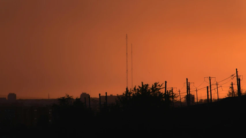 the sun is setting behind the power lines, a portrait, dust storm, radio signals, red and orange glow, journalism photo