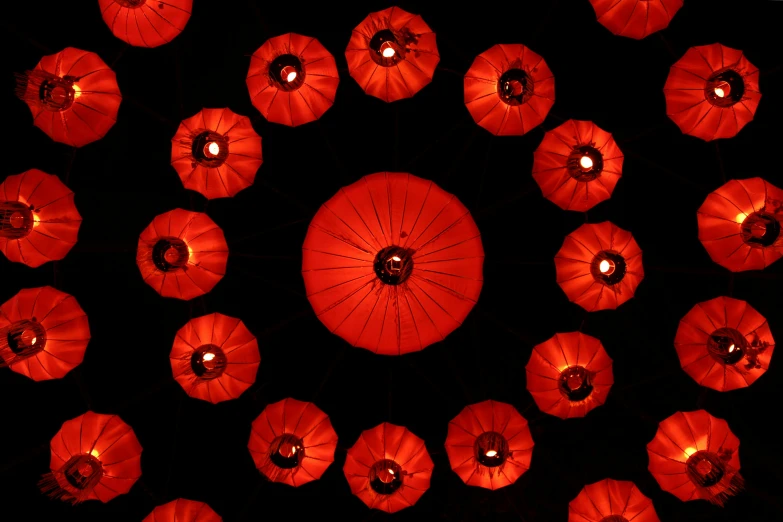 a group of red paper lanterns lit up in the dark, inspired by Li Di, kinetic art, radial symmetry, view from below, 2 0 1 0 s, cotton