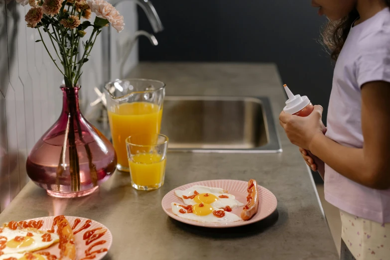 a little girl standing in front of a counter with a plate of food on it, inspired by Gillis Rombouts, trending on pexels, hyperrealism, eggs benedict cumberbatch, holding hot sauce, spraying liquid, hand on table