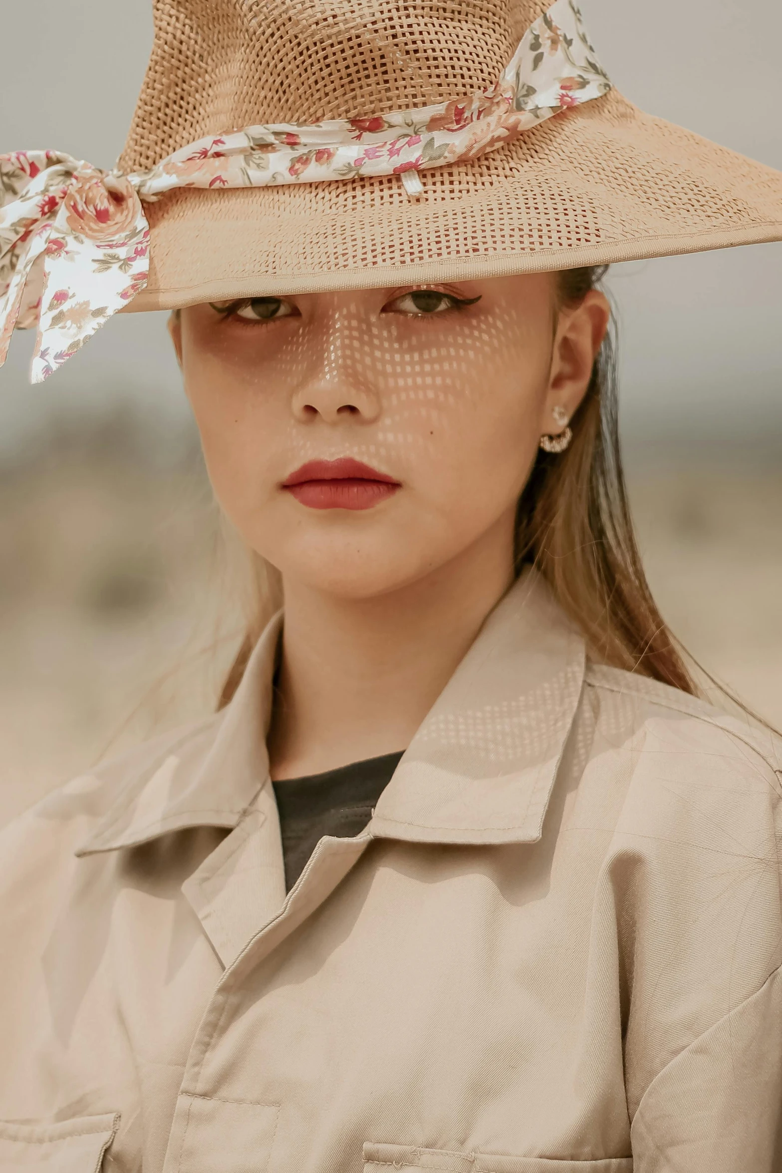 a woman wearing a hat in the desert, an album cover, by Emma Andijewska, trending on pexels, renaissance, detailed face of a asian girl, trenchcoat, non binary model, hong june hyung