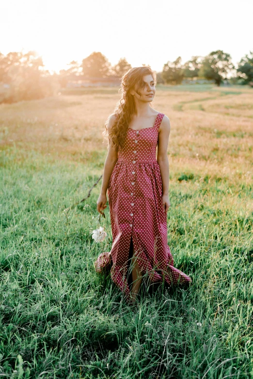 a woman in a red dress standing in a field, cute checkerboard sundress, organic dress, victorian inspired clothing, sundown