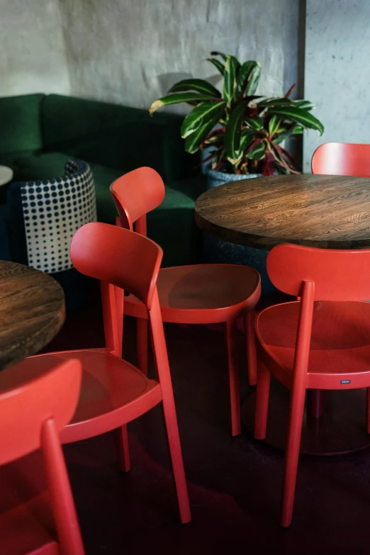 a group of red chairs sitting around a wooden table, zoomed in, bar, 2 colours, worn