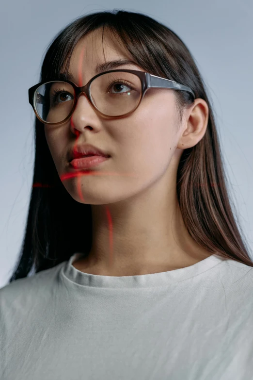 a woman in glasses with a red marker on her face, inspired by Ruth Jên, trending on pexels, hyperrealism, star trek asian woman, dynamic angled shot, thin red veins, technology