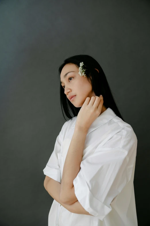 a woman with a flower in her hair, an album cover, by Tan Ting-pho, unsplash, wearing a white button up shirt, wearing simple robes, hand on her chin, natsumi mukai artwrok